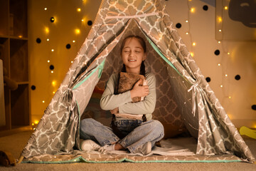 Cute girl with adventure book sitting in play tent at night © Pixel-Shot