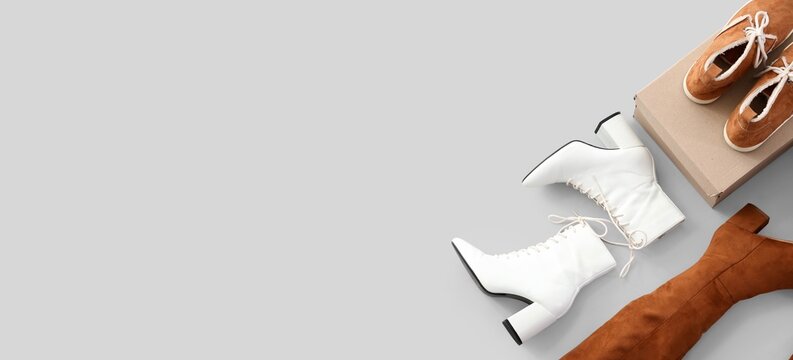 Fashionable women's footwear collection with white lace-up boots, brown suede boots, and casual shoes on a gray background