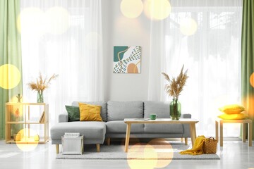Modern living room interior with comfortable gray sectional sofa, abstract wall art, and natural light from a large window © Pixel-Shot