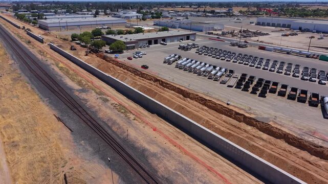 Still Aerial Drone Shot Over Train Track With California High Speed Rail Construction Intrusion Barrier Walls and Orange Safety Netting in Fresno California