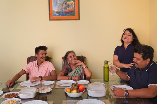 Happy family sitting around the dining table at home 