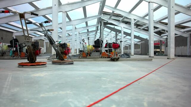 Power trowel machines smoothing concrete floor