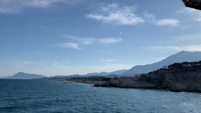 View of the Taurus mountain range and the peak of Mount Tahtali. The Mediterranean Sea in Camyuva, Kemer, Turkey. View from a ship in the open sea. Seascape. Kiris district.