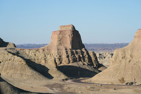 Erosional Mudstone Hills and Winding Road in Arid Desert Landscape

