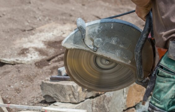 Masonry saw / brick saw in use at construction site to build a stone wall