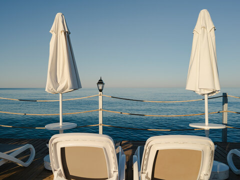 Sun loungers and umbrellas on a wooden beach pier