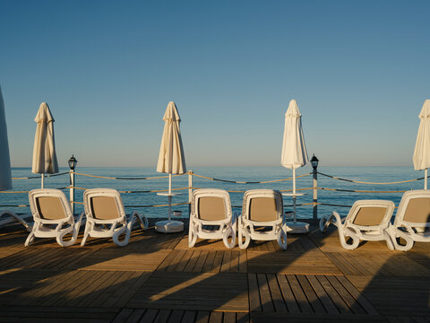 Sun loungers and umbrellas on a wooden beach pier