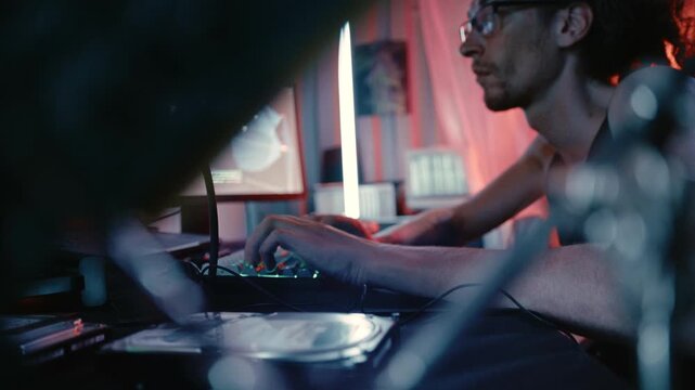 A cyberpunk-inspired workspace showing a technology operator inspecting hardware components in a hidden laboratory.
