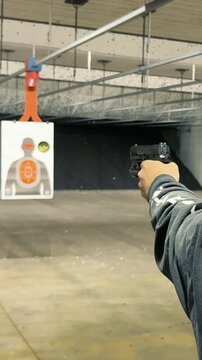 Shooting Range Practice, Person practicing firearm shooting at indoor range targets