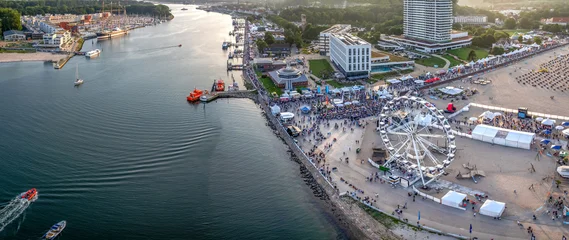 Aerial view of Travemünder Woche festival with a ferris wheel on the beach and the Trave river in Travemünde, Germany. © snapshotfreddy