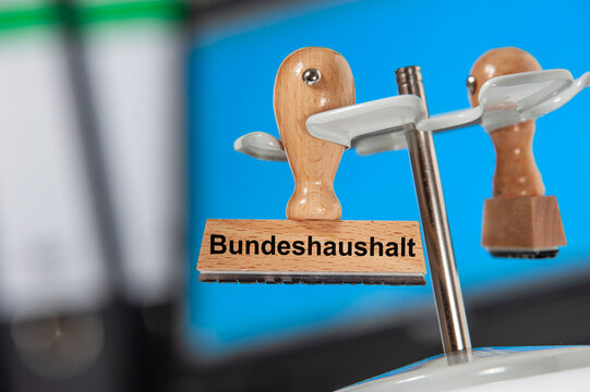 Ein Holzstempel ist beschriftet mit dem Aufdruck: Bundeshaushalt 2025