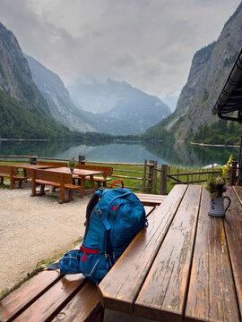 Peaceful Break hiking backpack on a Mountain Pasture in the Berchtesgaden Alps with a Mountain Lake in an Idyllic Landscape Vertical