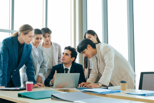 Corporate team discussing ideas and reviewing business information on a laptop. Professional collaboration, leadership and problem solving support effective project planning and business growth.