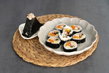Kimbap Rolls with Tuna Onigiri Served on Ceramic Plate © Blessape