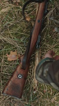 Overhead view of WWII German soldier loading magazine on forest floor