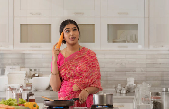 woman in kitchen thinking about dishes 