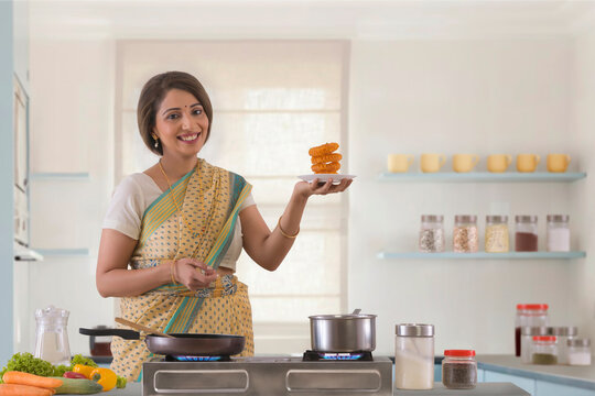 woman holding sweet dish in kitchen