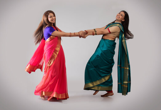 young women dancing in saree