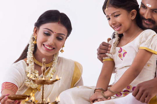 woman lighting lamp with a diya