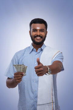 south indian man happy with his savings showing a thumbs up