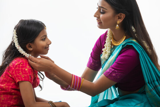 mother getting her daughter ready for an occasion