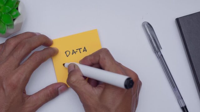 A man is writing Data Driven to illustrate all information with data is important