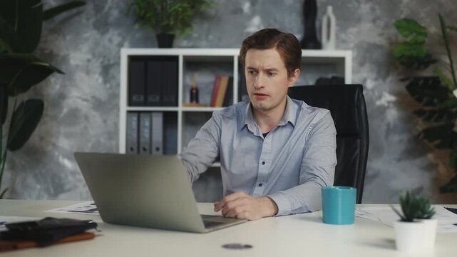 Overwhelmed young sales manager closing laptop, feeling stressed about workload