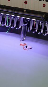 Industrial embroidery machine stitching red thread pattern