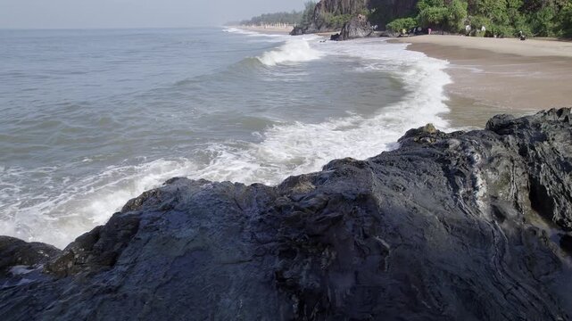 Drone view of waves crashing against rugged rocky shoreline creating dramatic coastal natural scenery