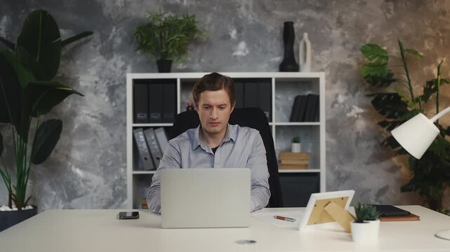 Successful young businessman closing laptop and going out for lunch break
