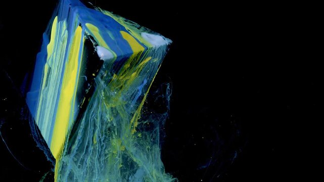Close oblique close-up of wedge-shaped object coated in thick layered paint with bold electric blue and neon yellow stripes and small white accents