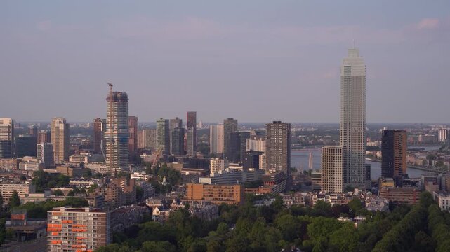 Panoramica skyline view of Rotterdam cityscape featuring the tall Zalmhaven tower and Erasmus Bridge, observed from the Euromast observation tower in the Netherlands.