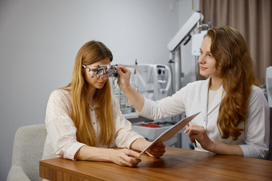 Patient receiving eye examination from specialist. Optical clinic featuring caring optometrist