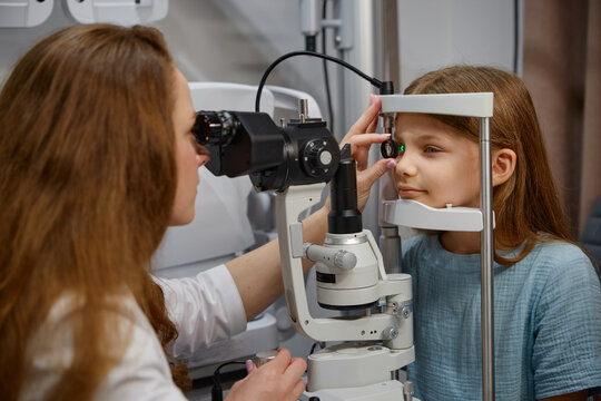 An experienced eye specialist conduct thorough examination for a young girl using modern tools