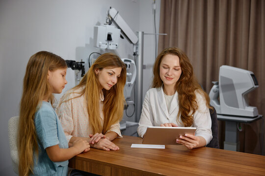 Child and mother undergo eye examination together. Pediatric eye screening conducted