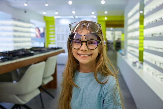 Stylish girl with teal shirt and glasses enjoying casual shopping experience