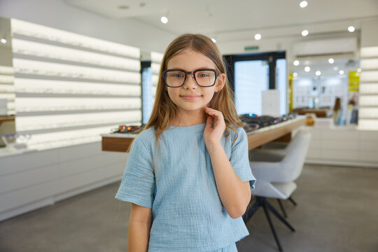 Girl showcasing fashionable glasses in a store