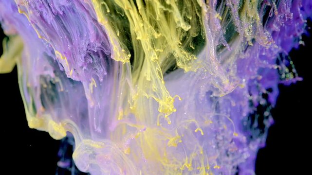 Close-up scene of purple and yellow pigments suspended in liquid against black backdrop, showing layered scalloped plumes, thin filaments, and curling tendrils