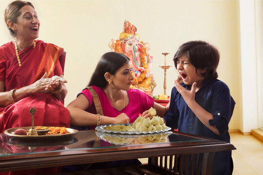Mother scolding son for eating the modak without her permission