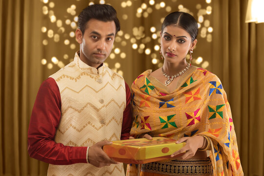 upset young couple holding present on diwali