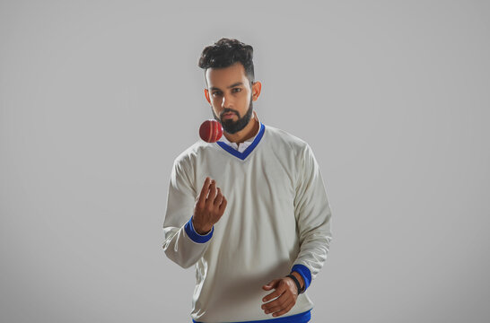 A bowler tossing the ball on grey background