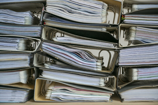Stacks of ring binders with many documents as full frame background, business concept for excessive bureaucracy, record keeping, accounting and work overload in the office