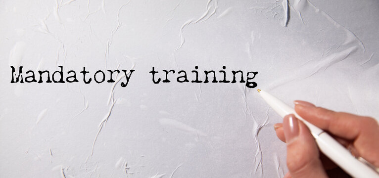 Mandatory training text on torn white paper