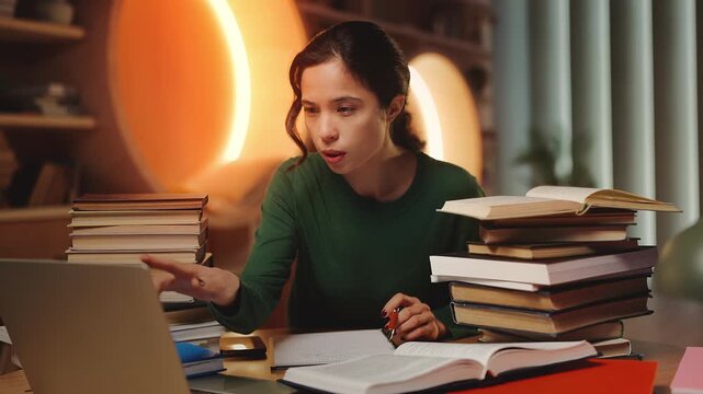 Tired Asian female student doing research behind stacks of books in library