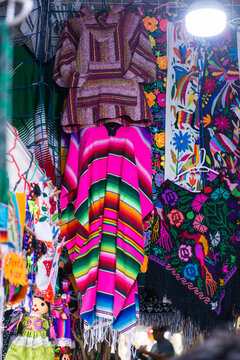 Traditional Mexican Serape Blanket and Artisan Textiles Displayed at Colorful Market Stall