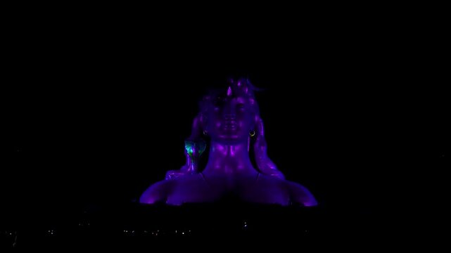 View of Adiyogi shiva statue illuminated by spectacular 3D laser light show at night