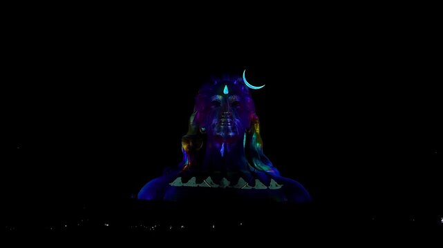 View of Adiyogi shiva statue illuminated by spectacular 3D laser light show at night