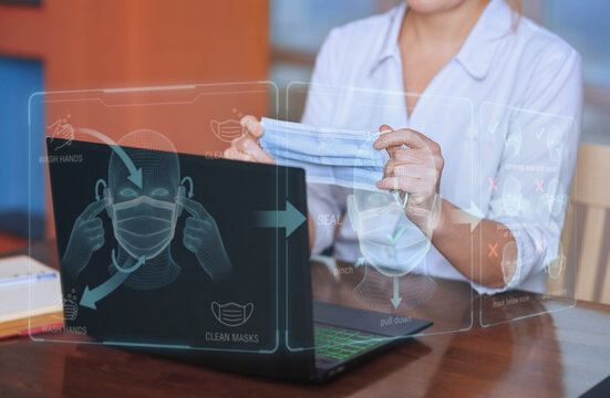 Doctor holding mask with futuristic hologram instruction indoors