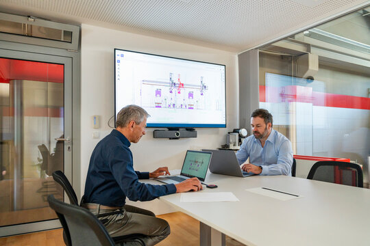 Businessman and engineer plan design on laptop in modern office
