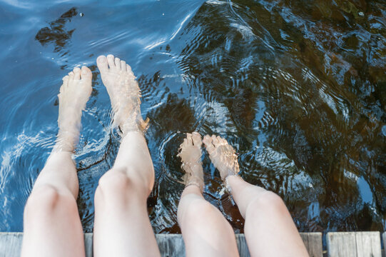 Finland, lake Saimaa, children splashing feet in water